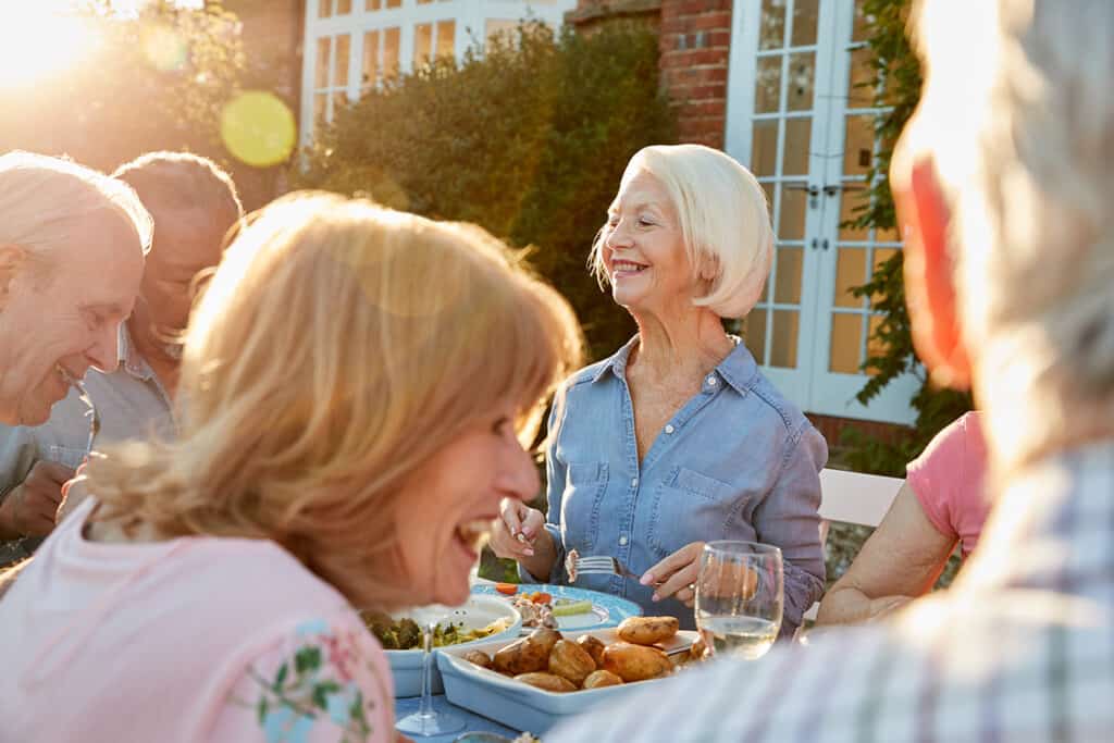Group Of Senior Friends Enjoying an Outdoor Dinner Party At Home