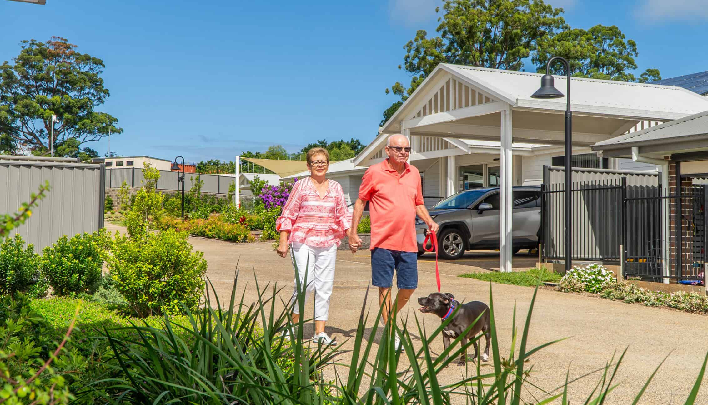 A couple enjoying a dog walk around our Coffs Harbour Retirement Village.