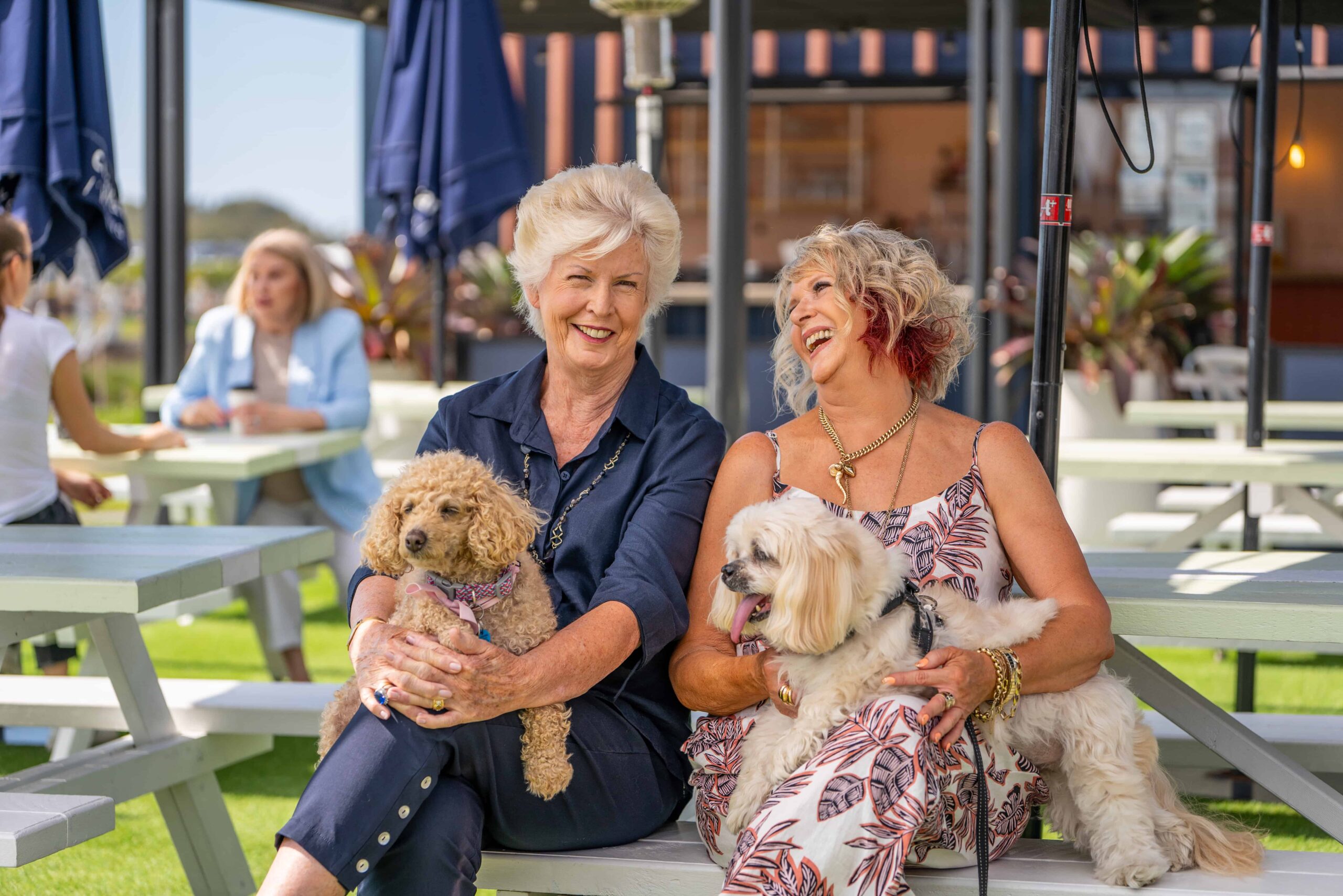 Two senior women and their dogs enjoying retirement living in an Oak Tree Retirement community.