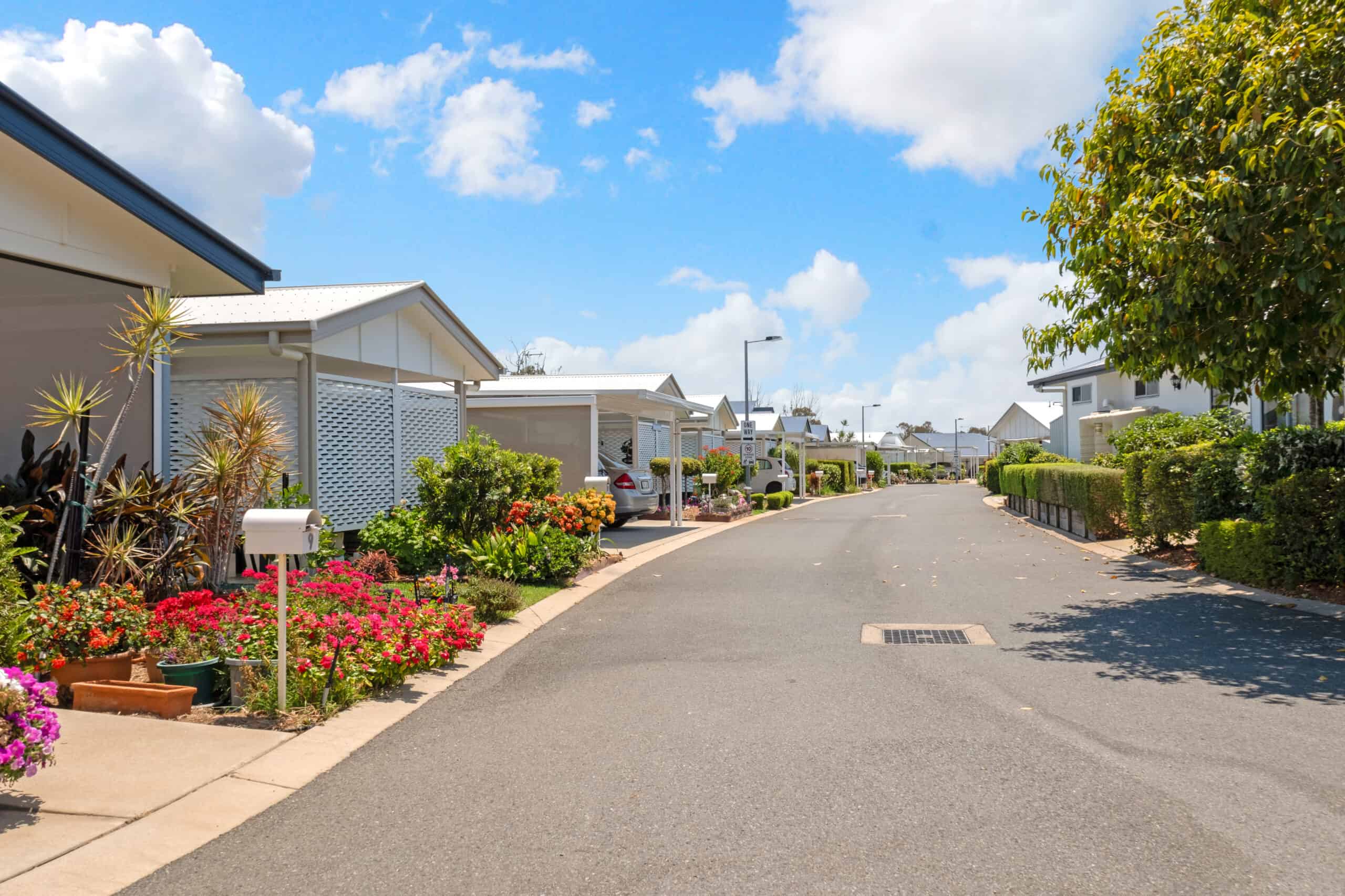 Street Lined with homes and beautiful flowers at Oak Tree Village Yeppoon Barmaryee Road