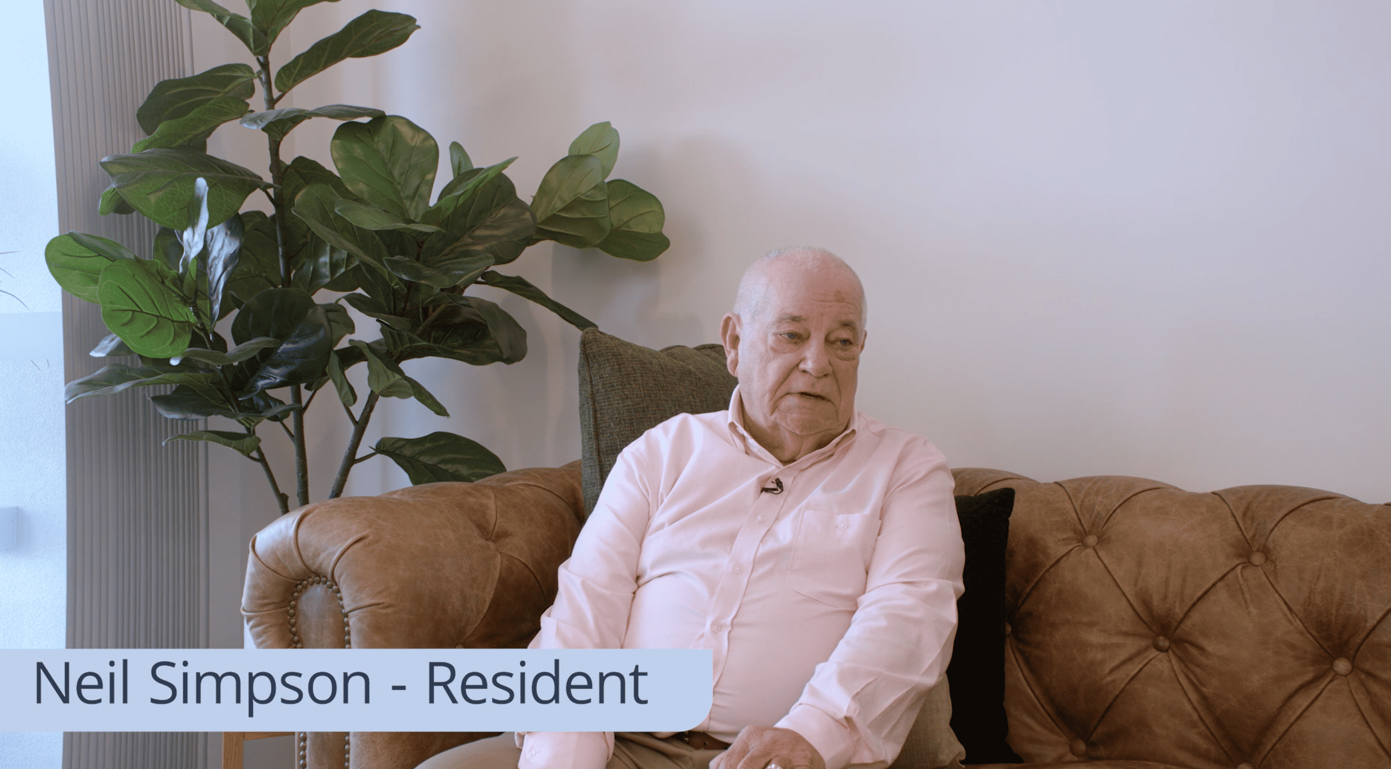 Neil Simpson, a senior male resident sitting on a sofa in his Oak Tree Retirement home.