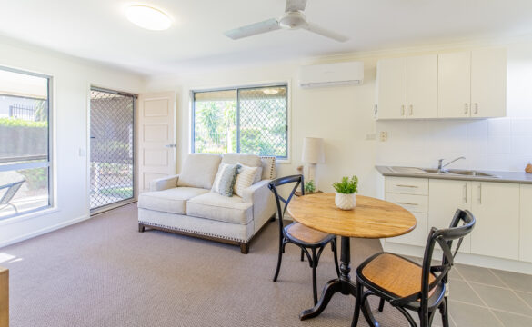 A compact kitchen, living room, and dining area in Goodna Villa 62, showcasing a modern, open-concept apartment layout.