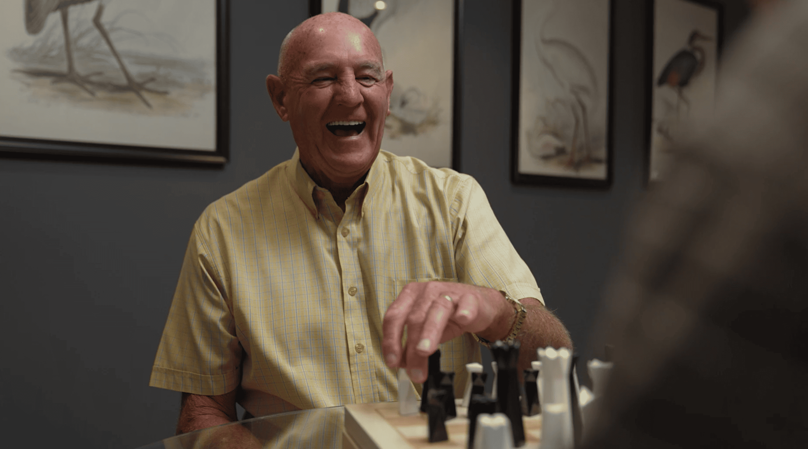 Senior man laughing and enjoying a game of chess at Oak Tree Jesmond.