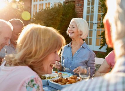 Group Of Senior Friends Enjoying Outdoor Dinner Party At Home