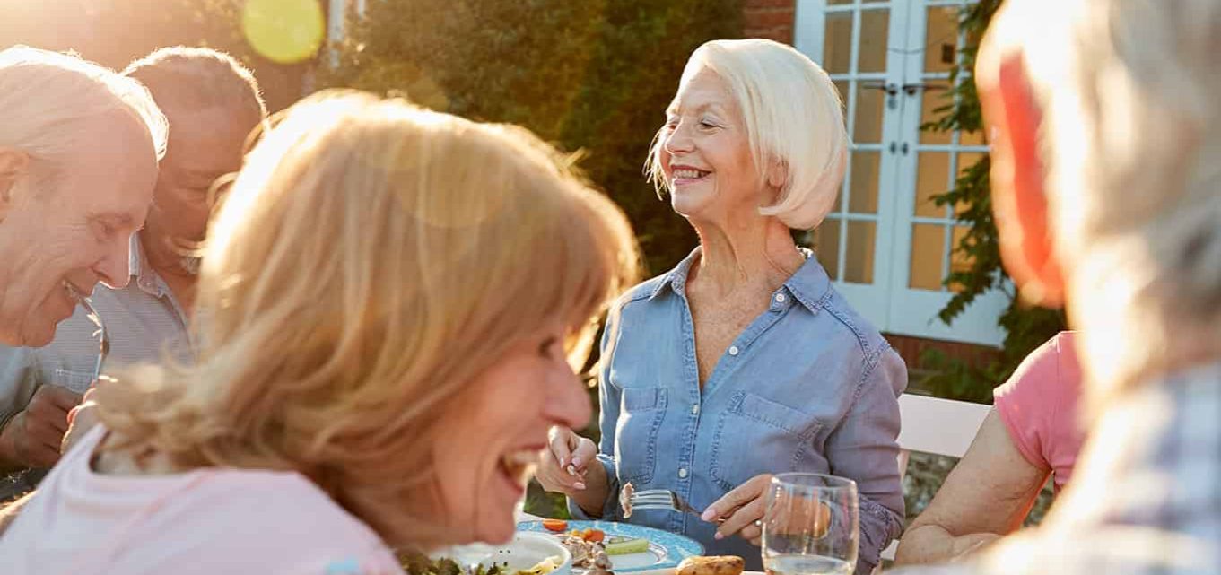 Group Of Senior Friends Enjoying an Outdoor Dinner Party At Home