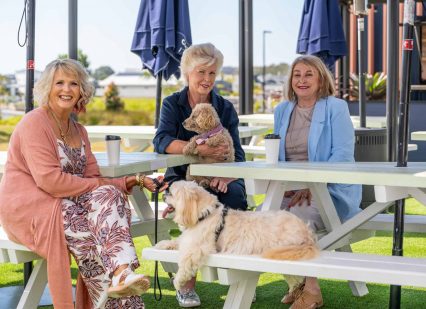 3 senior woman and two dogs enjoying spending time together at an Oak Tree Retirement Village