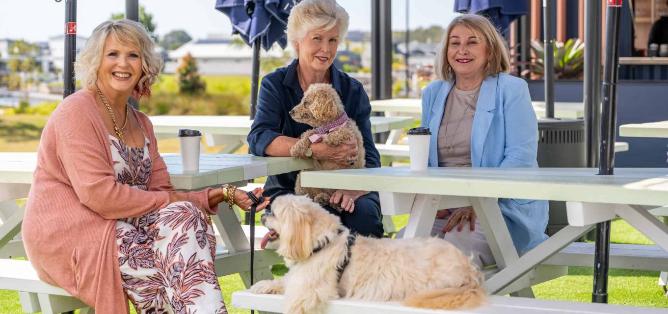 3 senior woman and two dogs enjoying spending time together at an Oak Tree Retirement Village