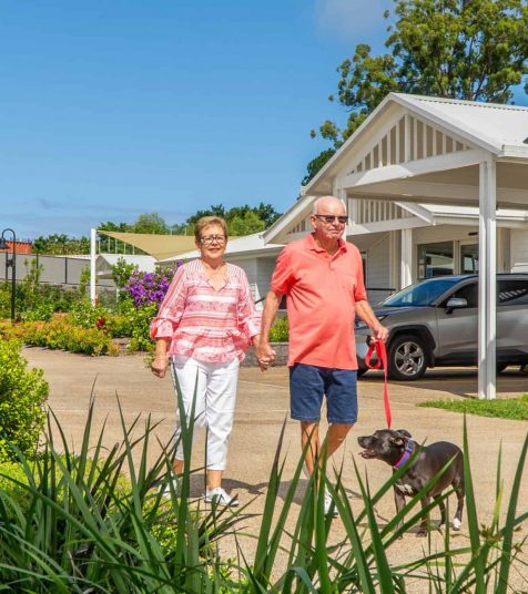 A couple enjoying a dog walk around our Coffs Harbour Retirement Village.