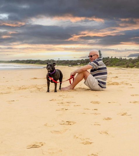 A man and his dog on the beach neat Coffs Harbour Retirement Village