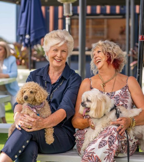 Two senior women and their dogs enjoying retirement living in an Oak Tree Retirement community.