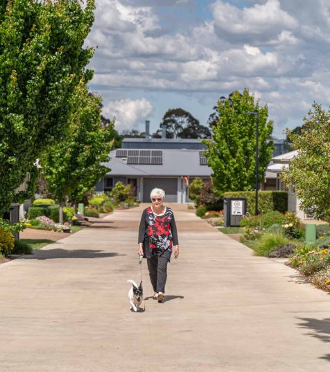 Senior woman taking her dog for a walk in one of our Oak Tree Retirement Villages