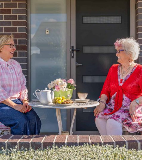 Senior women in conversation outside their Oak Tree Retirement Village homes